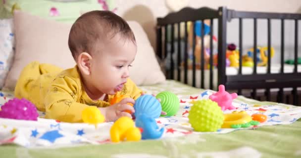 Criança, conceito de infância - close-up de sorrir feliz bebê brinca com um teether. Corte dos dentes. Os primeiros dentes. Joy toothless 7 meses bebê mordida, rói brinquedo teether — Vídeo de Stock