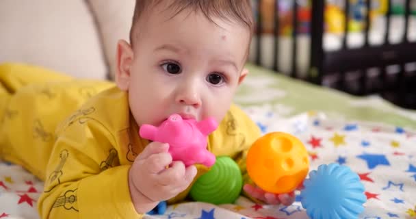 Zuigeling, kindertijd concept - close-up van lachende blije Baby speelt met een bijtring. Tanden knippen. Eerste tanden. Joy tandeloos 7 maanden baby beet, knagen bijtring speelgoed — Stockvideo