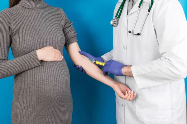 Newborn family concept. A pregnant woman with the hand of a doctor to vaccinate ,nurse vaccinating young girl having a child or young developing in the uterus.