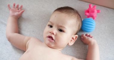 Bebek, çocukluk konsepti. Gülümseyen mutlu bebeğin ip ile oynadığı yakın plan. Diş kesimi. İlk dişler. Neşesiz dişsiz 7 ay bebek ısırığı, kemiren oyuncak