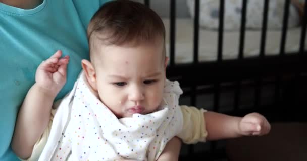 Mãe segura o bebê em seus braços e alimenta seu filho com uma colher. conceito de família, alimentação, criança, alimentação e paternidade — Vídeo de Stock