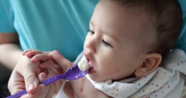 Madre tiene il bambino tra le braccia e lo nutre con un cucchiaio. famiglia, cibo, bambino, mangiare e concetto di genitorialità — Video Stock