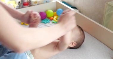 Jimnastik bebeğim. Gelişim süreci için çocuğuyla egzersiz yapan bir kadın. Yeni doğmuş küçük bir bebeğe masaj yapar, kollarında egzersiz yapar. Ebeveynlik kavramı, çocukluk, annelik, annelik. yavaş çekim