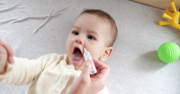 Kvinna som använder näsdroppar för bebisen. Nasal instillation för baby. Flickan gråter på grund av sjukdom och snor. slow motion — Stockvideo