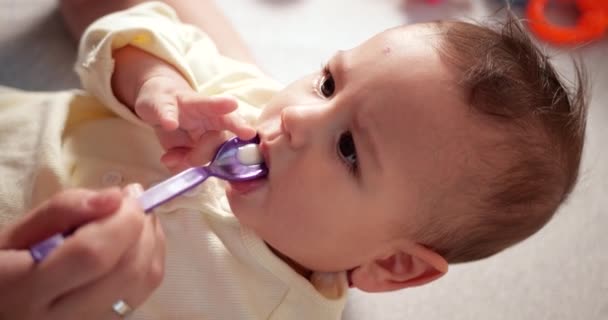 Hände von Mutti, die dem kranken kleinen Sohn Hustensaft auf einem Löffel verabreicht. Gesundheit und Medizin Babykonzept. Zeitlupe — Stockvideo