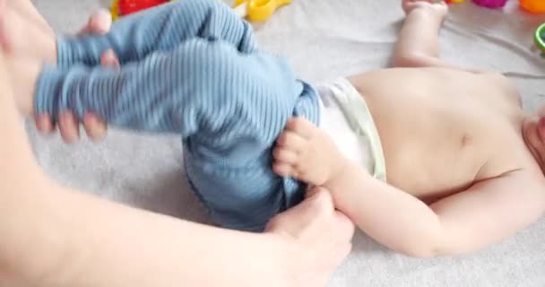 Maman habille un petit garçon qui pleure sur le lit. Médecine santé, famille, innocence, pédiatrie bonheur, concepts infantiles. au ralenti — Video