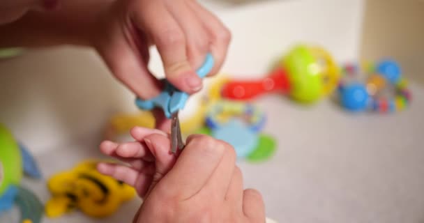 Maman coupe ses ongles de fils lettle sur la main. Une femme utilise de petits ciseaux de sécurité pour bébé. au ralenti — Video