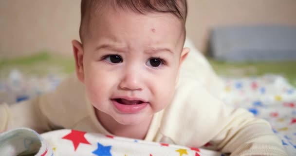Bebek, çocukluk konsepti - Ağlayan Bebek 'in yakın çekimi ip ile oynuyor. Diş kesimi. İlk dişler. Neşesiz dişsiz 7 ay bebek ısırığı, kemiren oyuncak — Stok video