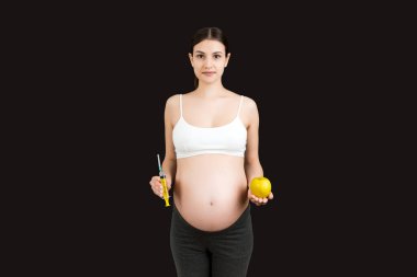 Karnına renkli bir şırınga dayayan hamile bir kadın fotokopi çekiyordu. Hamilelik konsepti sırasında iğne.