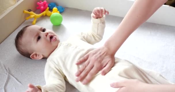 Moeder masseren kleine baby .Baby huidverzorging en ontwikkeling concept. Preventie van koliek. Vrouwelijke handen doen buikmassage bij pasgeborenen. slow motion — Stockvideo