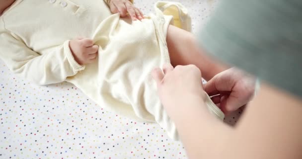 Mamma klär en gråtande liten pojke på sängen. Medicin, sjukvård, familj, oskuld pediatrik, lycka, spädbarnskoncept. slow motion — Stockvideo