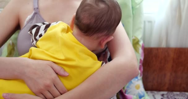 Мать кормит грудью своего новорожденного ребенка на диване. Молоко от материнской груди является естественным лекарством для ребенка. Семья, еда, ребенок, еда и паранормальное питание. замедленное движение — стоковое видео