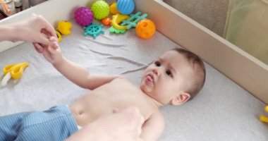 Jimnastik bebeğim. Gelişim süreci için çocuğuyla egzersiz yapan bir kadın. Yeni doğmuş küçük bir bebeğe masaj yapar, kollarında egzersiz yapar. Ebeveynlik kavramı, çocukluk, annelik, annelik. yavaş çekim