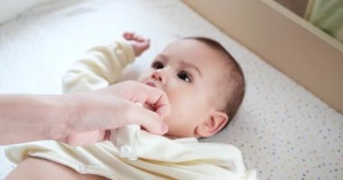 Annem ağlayan küçük bir çocuğu yatakta giydirir. Sağlık sigortası, aile, masumiyet, pediatri, mutluluk, bebek konseptleri. yavaş çekim