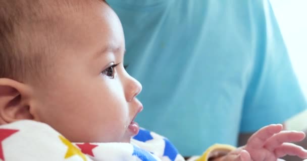 Madre sostiene al bebé en sus brazos y alimenta a su hijo con una cuchara. familia, comida, niño, alimentación y concepto de paternidad. cámara lenta — Vídeo de stock