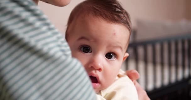 Una giovane madre sta tenendo un bellissimo figlio di sette mesi che sorride e rode le dita e le madri mano. denti pruriginosi di un neonato, dentizione. rallentatore — Video Stock