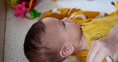 Annem küçük bir çocuğu yatakta giydirir. Tıp, sağlık, aile, masumiyet çocuk hastalıkları mutluluk bebek konseptleri. yavaş çekim