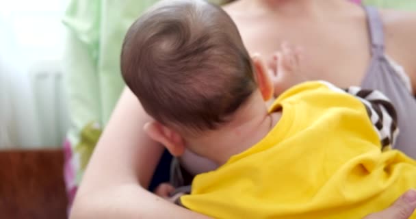 Madre amamantando a su bebé recién nacido en el sofá. La leche materna es una medicina natural para el bebé. familia, comida, niño, alimentación y concepto de paternidad. cámara lenta — Vídeos de Stock