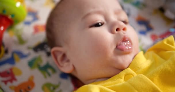 Bonito menino bebê bebê recém-nascido criança retrato sorrindo para câmera olhando. câmara lenta — Vídeo de Stock