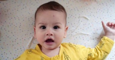 Sevimli küçük erkek bebek yeni doğmuş bebek portresi kameraya gülümsüyor. yavaş çekim