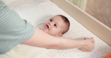 Jimnastik bebeğim. Gelişim süreci için çocuğuyla egzersiz yapan bir kadın. Yeni doğmuş küçük bir bebeğe masaj yapar, kollarında egzersiz yapar. Ebeveynlik kavramı, çocukluk, annelik, annelik. yavaş çekim