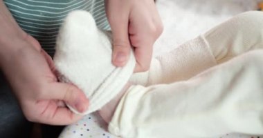 Annem evde yeni doğmuş bebek ayaklarına çorap giyer.