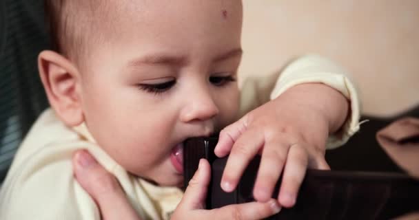 Das Kind spielt mit der Krippe. Zähneknirschen. Erste Zähne. 7 Monate altes Baby beißt zu, nagt an der Bettkante statt an den Zähnen. Baby, Kindheitskonzept. Zeitlupe — Stockvideo