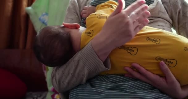 Мать кормит грудью своего новорожденного ребенка на диване. Молоко из материнской груди является естественным лекарством для ребенка. Семья, еда, ребенок, еда и паранормальное питание. замедленное движение — стоковое видео