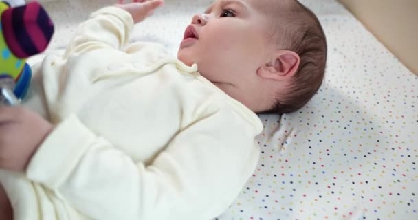 Bebé, concepto de la infancia - primer plano de sonreír feliz Bebé juega con un mordedor. Cortar los dientes. Primeros dientes. Joy mordida de bebé sin dientes de 7 meses, roe el juguete del mordedor. cámara lenta — Vídeos de Stock