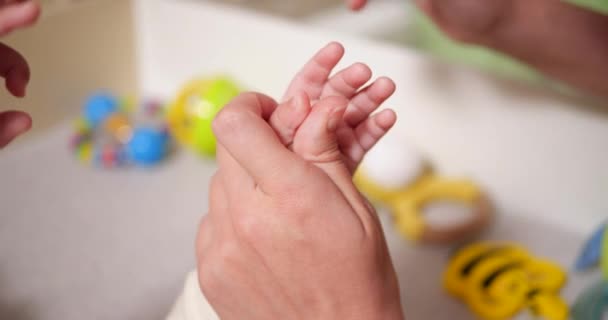 A mãe corta as unhas do seu filho. Uma mulher usa uma pequena tesoura de segurança para bebés. câmara lenta — Vídeo de Stock