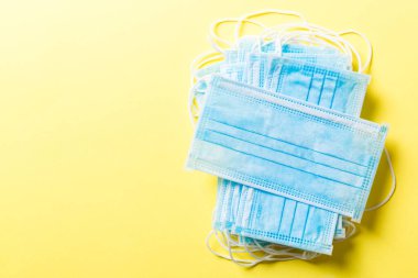 Renkli arka plandaki tıbbi maske yığınına yazılan virüs salgınını kapat. Wuhan virüsü. Dünya salgını.