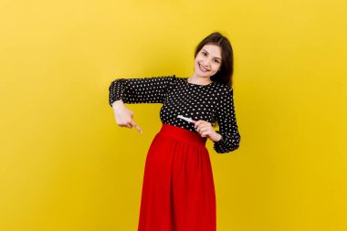 Renkli arka planda mutlu hamile kadın karnına karşı iki şeritli pozitif hamilelik testi. Gri elbiseli müstakbel anne. Hamilelik sürprizi. Boşluğu kopyala.