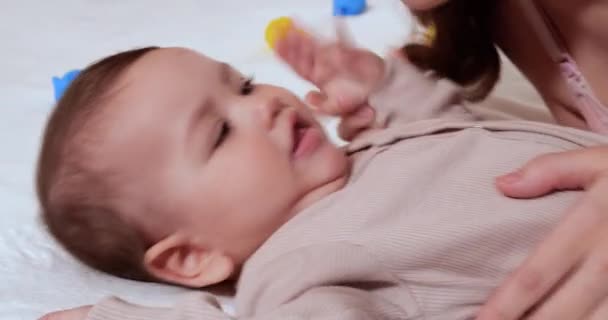 Zuigeling, kindertijd concept - close-up van lachende blije Baby speelt met een bijtring. Tanden knippen. Eerste tanden. Joy tandeloos 7 maanden baby beet, knagen bijtring speelgoed — Stockvideo