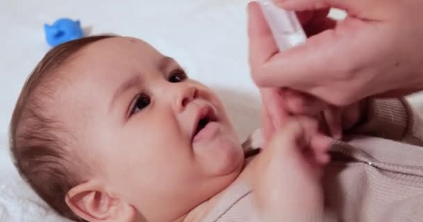 Anne bebek için burun damlası kullanıyor. Bebek için burun enjeksiyonu. Bebek çocuk, hastalık ve sümük yüzünden ağlıyor. — Stok video
