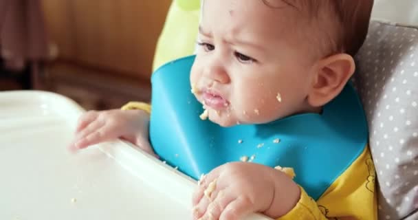 Mãe segura o bebê em seus braços e alimenta seu filho com uma colher. conceito de família, alimentação, criança, alimentação e paternidade — Vídeo de Stock