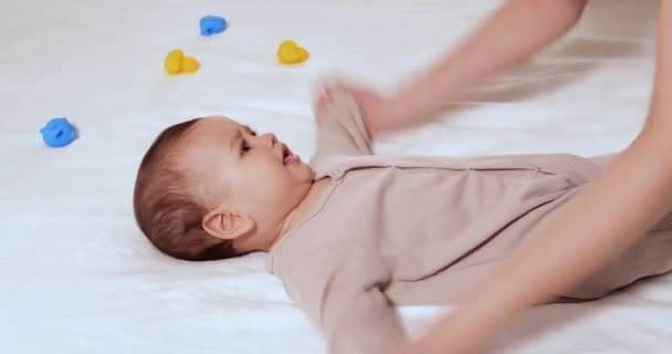 Dziecko z gimnastyki. kobieta robi ćwiczenia z dzieckiem dla jego rozwoju. masaż małego noworodka, ćwiczenia na ramionach. Pojęcie rodzicielstwa, dzieciństwa, macierzyństwa, macierzyństwa — Wideo stockowe