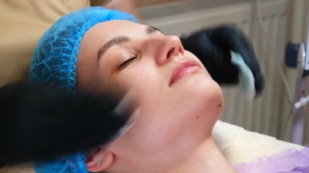 Cosmetologist médico esfregando rosto mulher usa almofadas de algodão após o procedimento de descascamento. O médico está a fazer um procedimento de beleza na clínica de cosmetologia. Cuidado com a pele do rosto — Vídeo de Stock