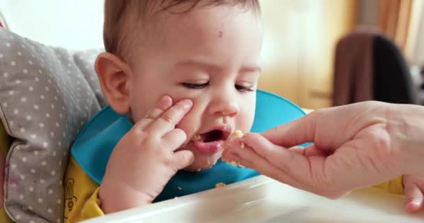 Madre tiene il bambino tra le braccia e lo nutre con un cucchiaio. famiglia, cibo, bambino, mangiare e concetto di genitorialità — Video Stock