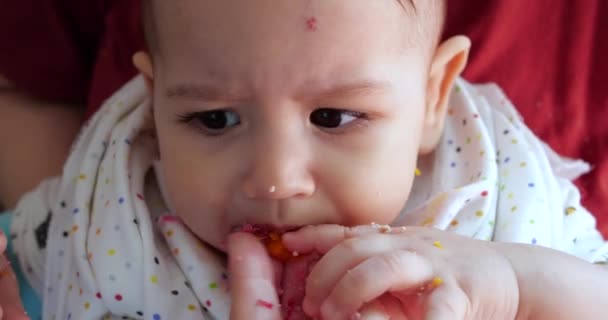 Moeder houdt de baby in haar armen en voedt haar zoon met een lepel. familie, voedsel, kind, eten en ouderschap concept — Stockvideo