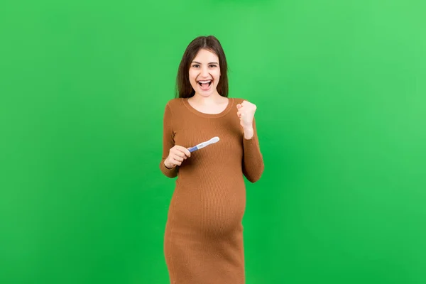 Dodatni Wynik Testu Ciążowego Dwoma Paskami Przeciwko Szczęśliwej Ciężarnej Kobiecie — Zdjęcie stockowe
