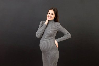 Mutlu hamile kadın renkli arka planda karnına dokunuyor. Müstakbel anne. Bir bebek bekliyorduk. Boşluğu kopyala.