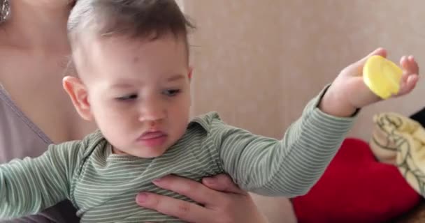 Mutter kämmt die Haare auf dem Babykopf, während er in den Armen der Mutter sitzt — Stockvideo