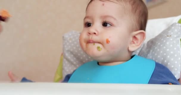 Mamá alimenta al niño con una cuchara y una mano, comida familiar y concepto de paternidad. primeros alimentos complementarios y autoalimentación — Vídeo de stock