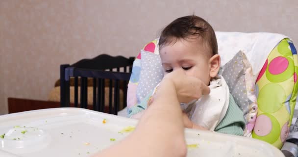 Mam voedt de jongen met een lepel en hand, familie eten en ouderschap concept. eerste aanvullende levensmiddelen en zelfvoeding — Stockvideo