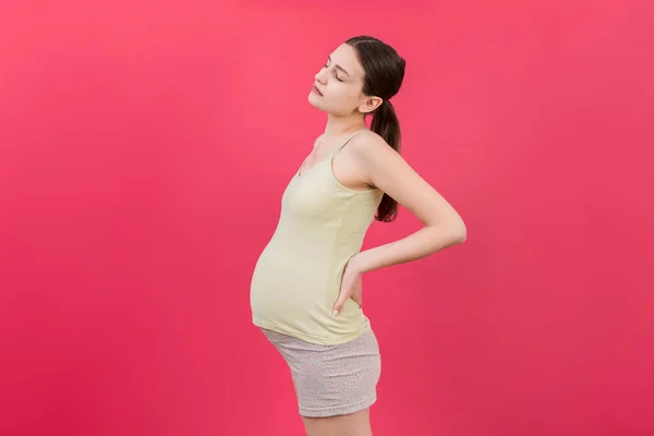 Mulher Grávida Com Uma Dor Nas Costas Fundo Colorido Isolado — Fotografia de Stock