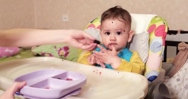 Mamá alimenta al niño con una cuchara y una mano, comida familiar y concepto de paternidad. primeros alimentos complementarios y autoalimentación — Vídeo de stock