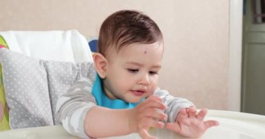 Anne çocuğu kaşıkla ve elle besler, aile yemeği ve ebeveynlik konseptiyle. İlk tamamlayıcı gıda ve kendini besleme.