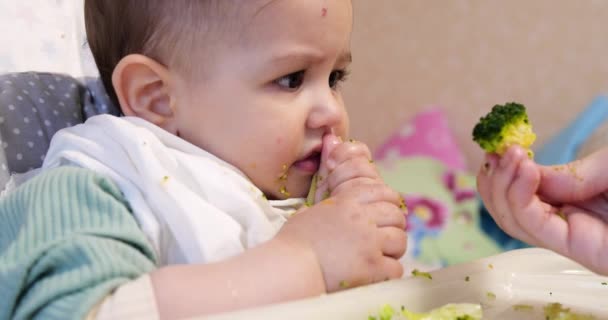 Mam voedt de jongen met een lepel en hand, familie eten en ouderschap concept. eerste aanvullende levensmiddelen en zelfvoeding — Stockvideo