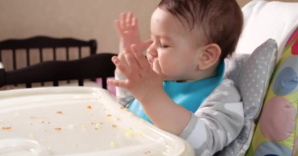 Η μαμά ταΐζει το αγόρι με ένα κουτάλι και ένα χέρι, οικογενειακό φαγητό και την έννοια της πατρότητας. πρώτα συμπληρωματικά τρόφιμα και αυτοσίτιση — Αρχείο Βίντεο