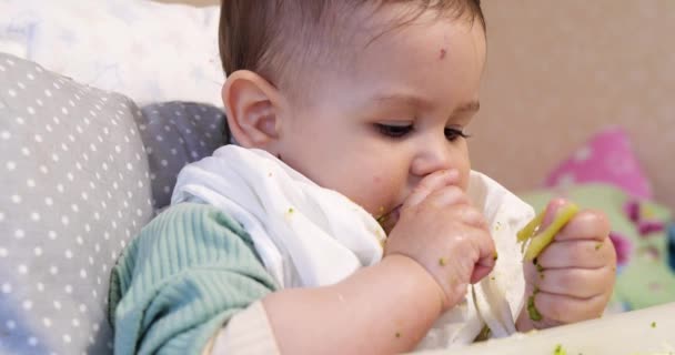 Mamãe alimenta o menino com uma colher e mão, comida familiar e conceito de paternidade. primeiros alimentos complementares e auto-alimentação — Vídeo de Stock